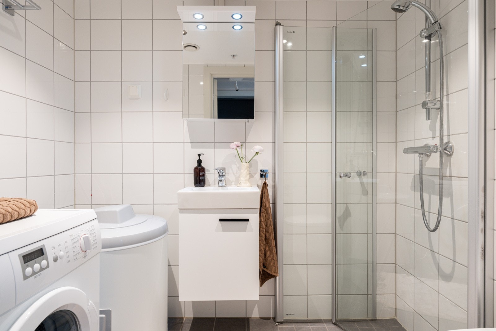 Leiligheten har et lyst og moderne baderom fra 2015. Baderommet har grå fliser på gulv, elektriske varmekabler, lyse fliser på veggene, downlights i himlingen og mekanisk avtrekk. Galleribilde