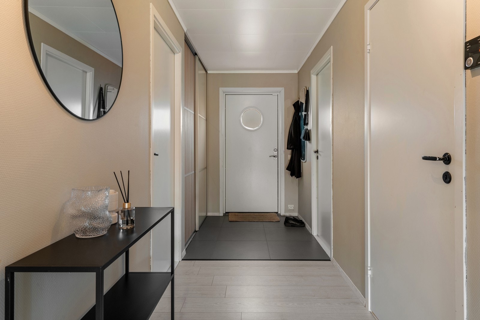 Romslig gang med flislagt inngangsparti og skyvedørsgarderobe. Galleribilde