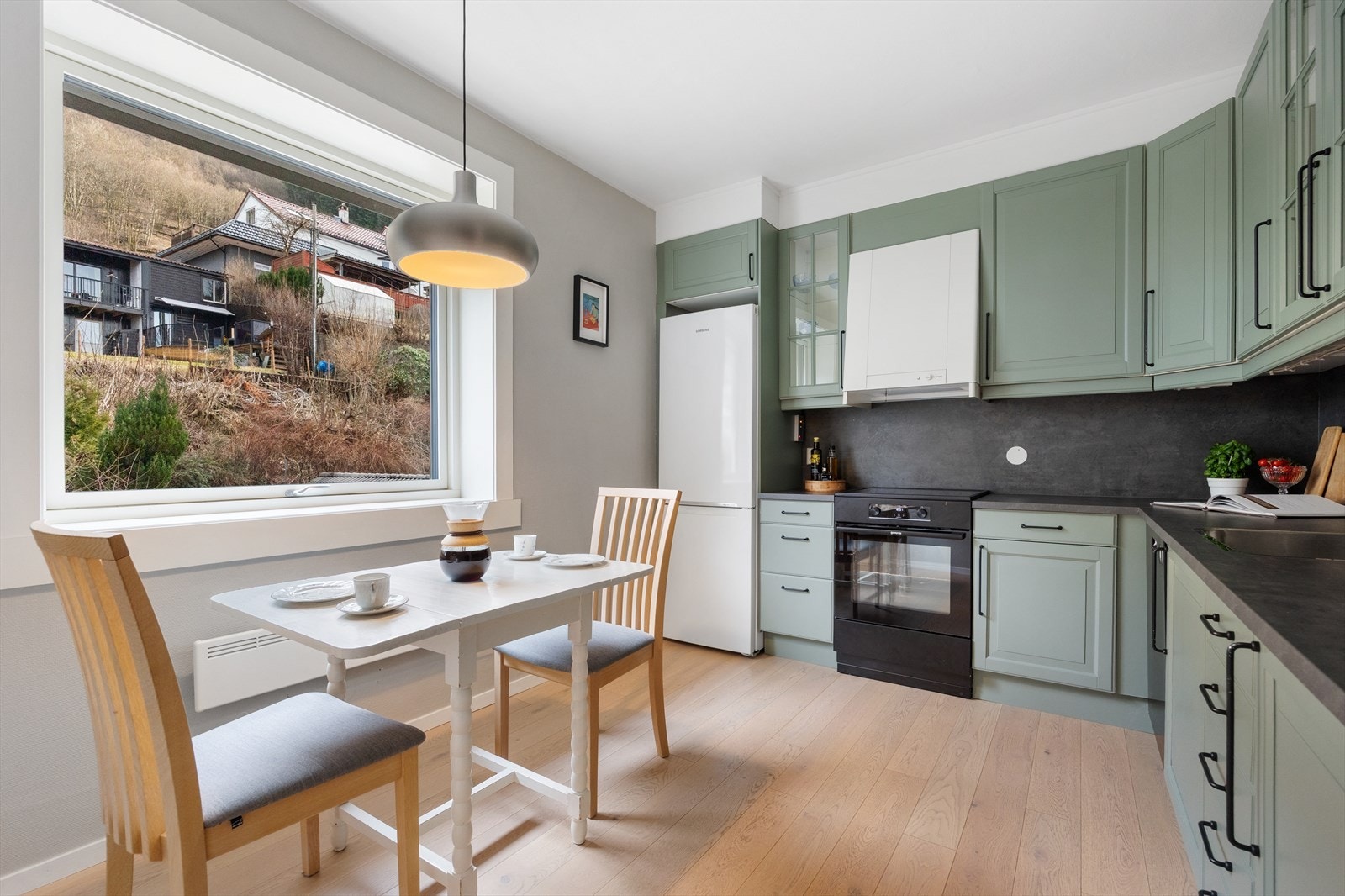 Kjøkkeninnredning med laminert benkeplate, nedfelt stålvask, profilerte fronter og opplegg for oppvaskmaskin. Galleribilde