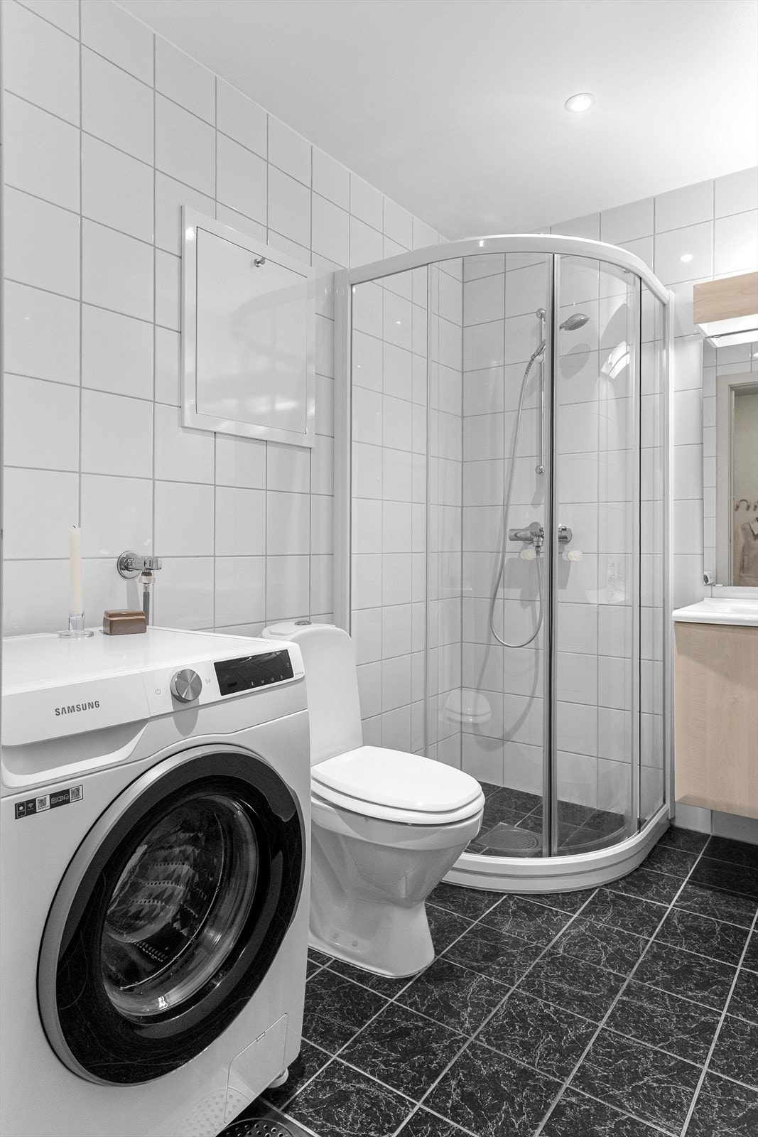 Badet er innredet med wc, servant med underskap samt speil og stikkontakt over, dusjhjørne og opplegg for vaskemaskin. Galleribilde