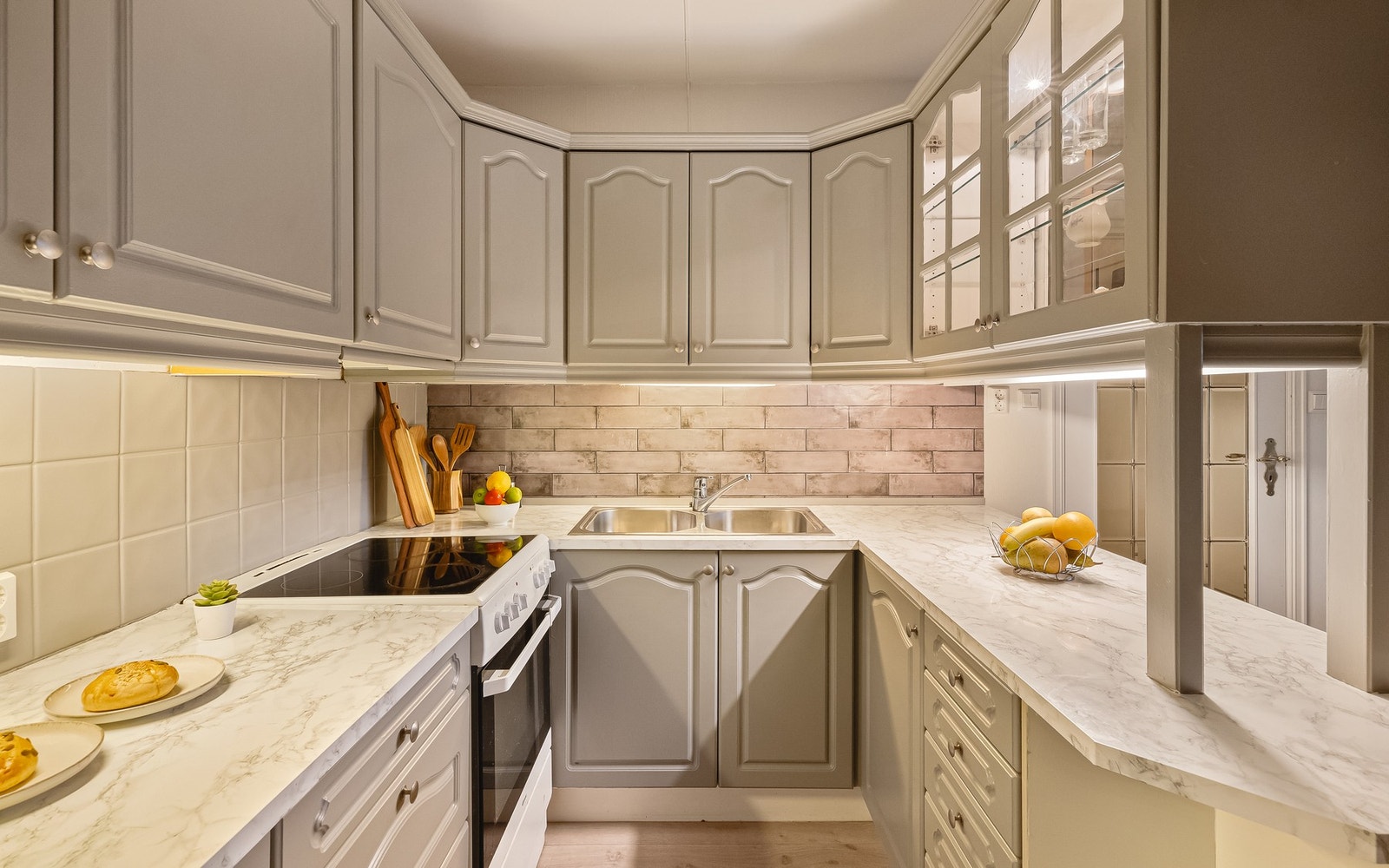 - Kjøkkenet ligger i tilknytning til stuen og fremstår lyst og trivelig med profilerte fronter, vitrineskap og laminat benkeplate - Galleribilde