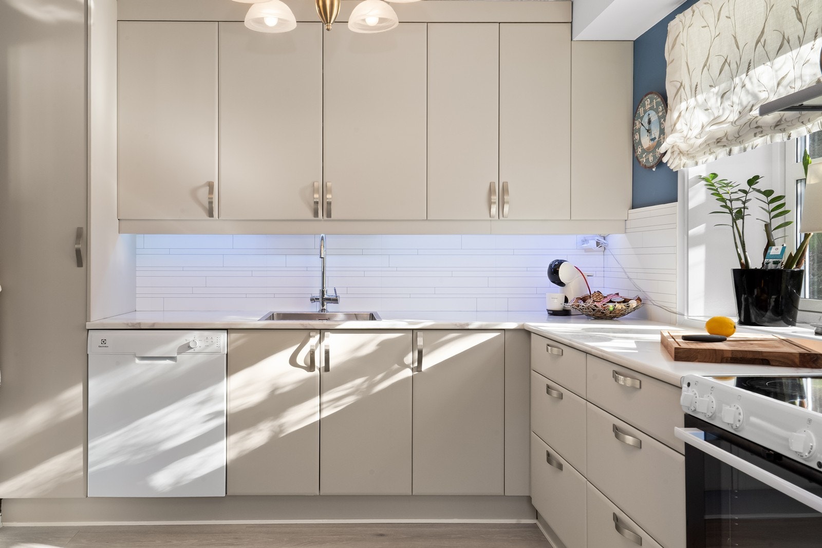 Innredningen har slette fronter og laminerte benkeplater. Det er montert belysning og fuktbestandige plater på veggen mellom skapene. Galleribilde