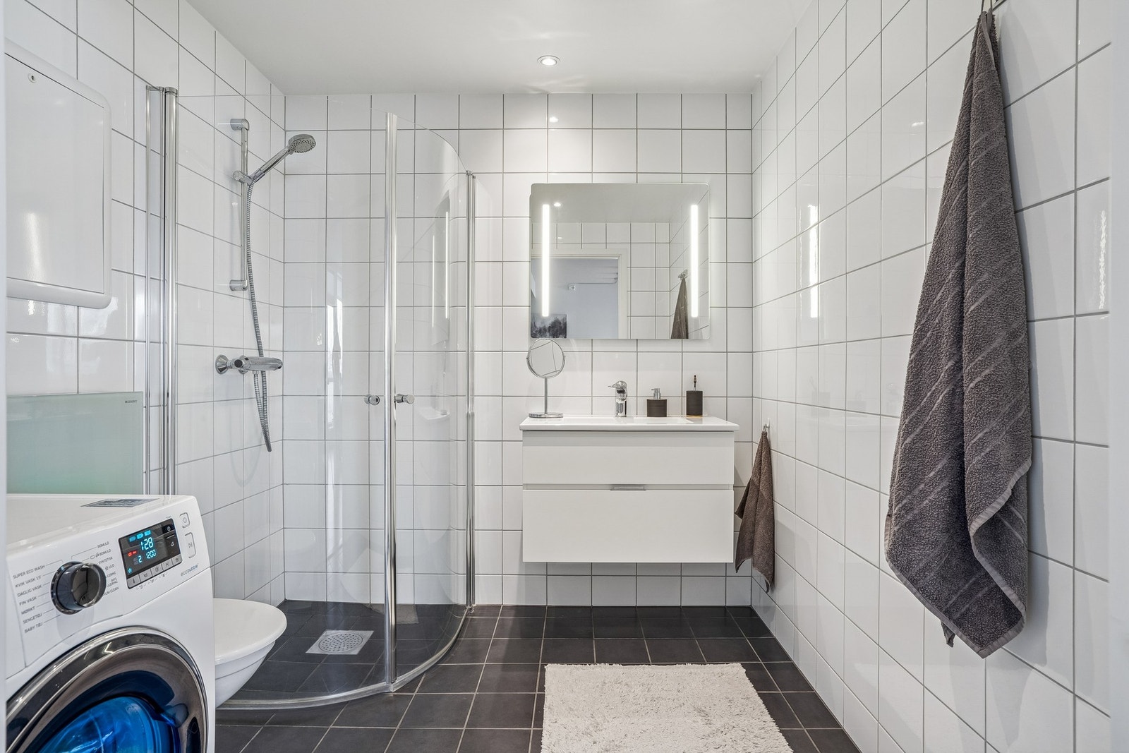 Rommet er smart innredet med både baderomsfunksjon og vaskerom i ett, noe som gir en svært praktisk og effektiv hverdag. Galleribilde