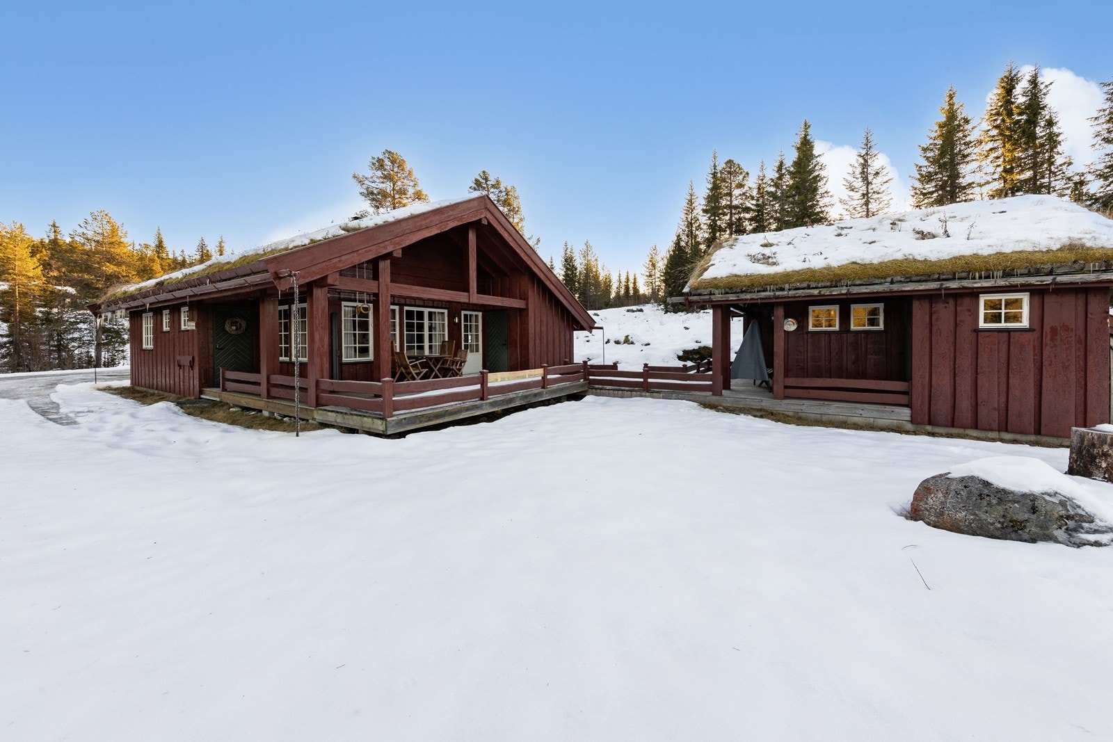 Tomten er en relativt flat naturtomt, hvor en terrasseplatting binder hytte og anneks sammen. Galleribilde