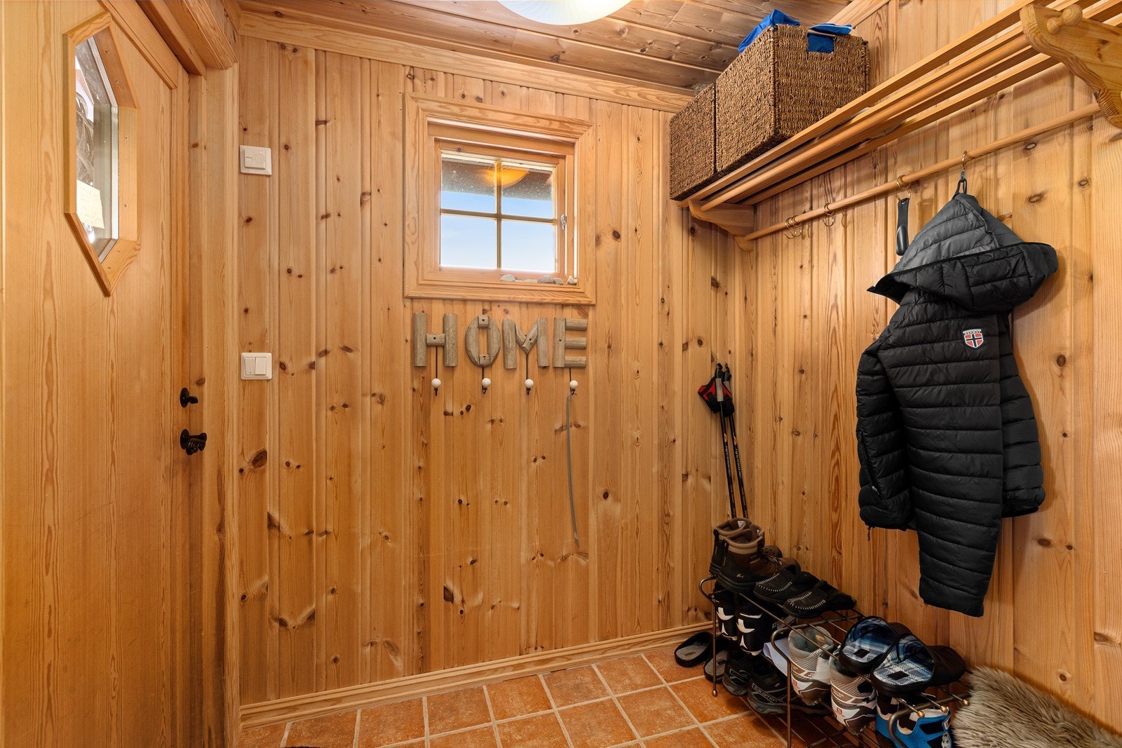 Man ønskes velkommen inn i en flislagt entré med plass til å henge fra seg yttertøy og sette fra seg sko. Entreen er utstyrt med varmekabler. Galleribilde