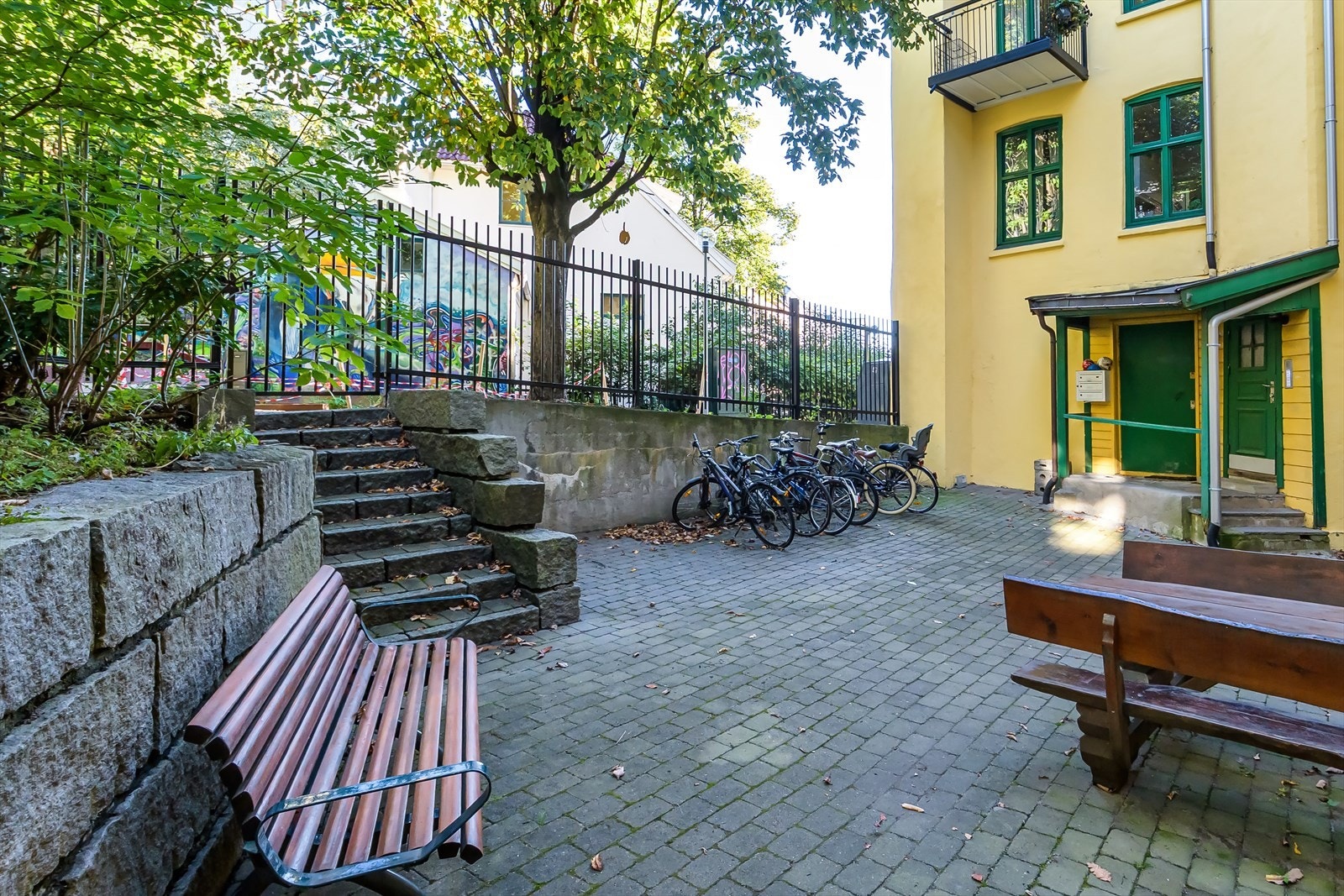 Låst port fører deg direkte til nyoppussede Gartnerløkka med sitteplasser, lekeplass og grøntareal. Galleribilde