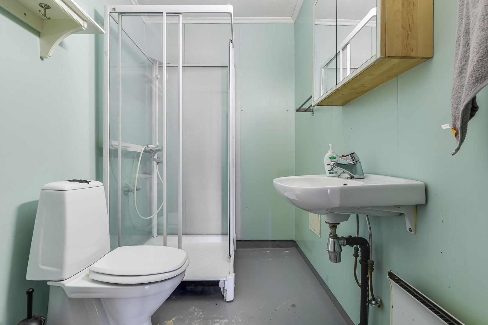 Eldre bad med vask, toalett og dusjkabinett. Badet må oppgraderes for å tåle normal bruk etter dagens krav. Galleribilde