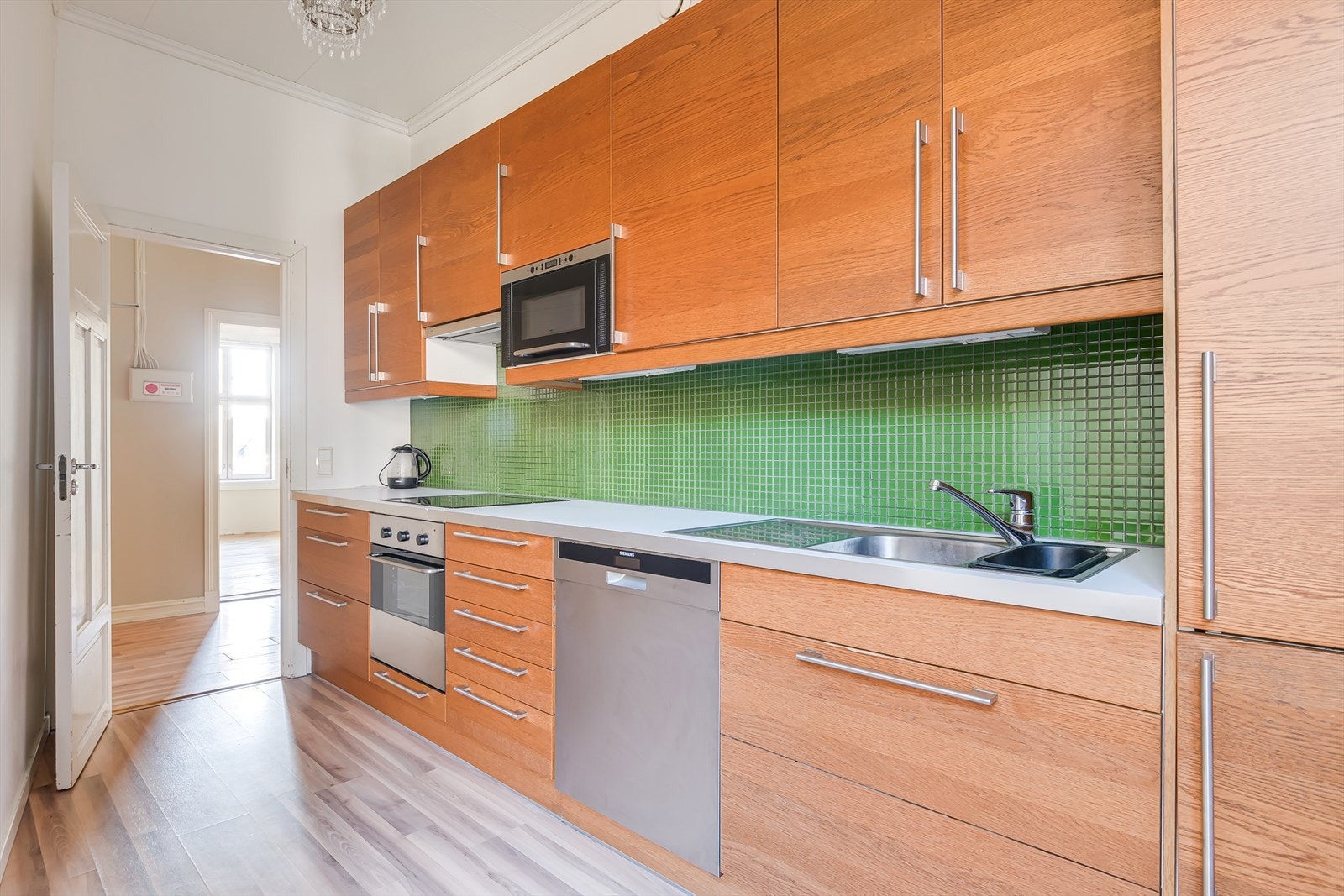 Kjøkkenet er utstyrt med integrerte hvitevarer som koketopp, stekeovn, kjøl/- fryseskap, og frittstående oppvaskmaskin. Galleribilde