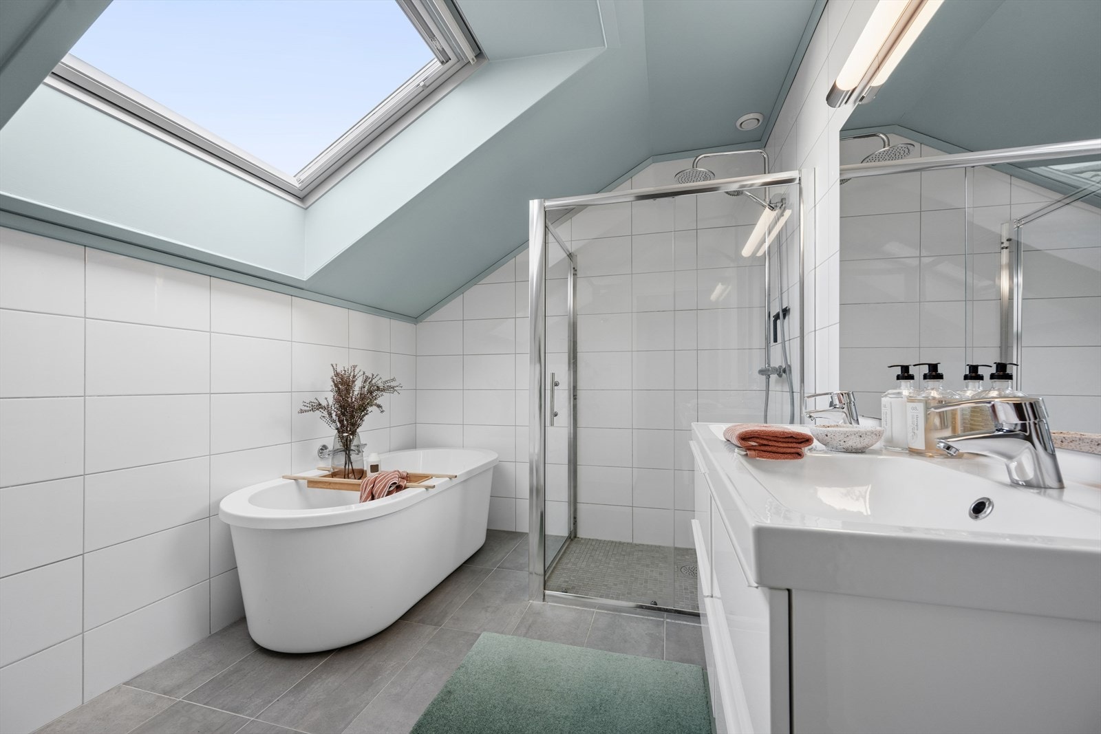 Baderommet er pent innredet med både badekar og dusjnisje med glassdør. Galleribilde