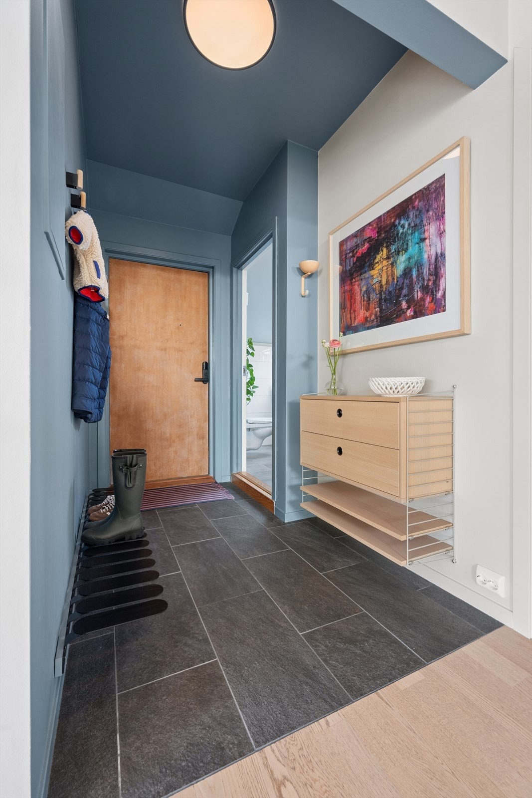 En praktisk gang ønsker deg velkommen inn og forbinder leilighetens ulike rom. Galleribilde