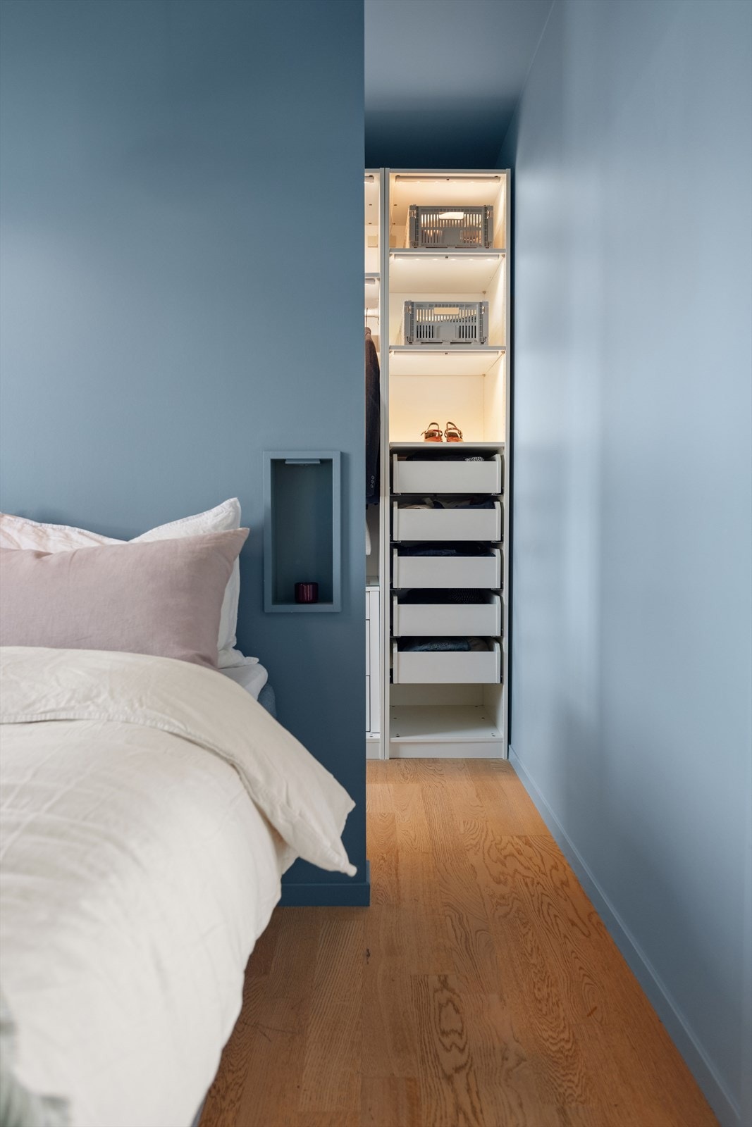 En smart lettvegg skaper en praktisk walk-in garderobeløsning med god oppbevaringsplass. Galleribilde