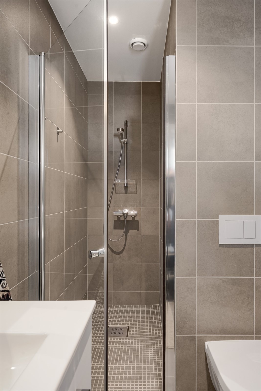 Baderommet er også utstyrt med dusjnisje med glassdør og vegghengt toalett. Galleribilde