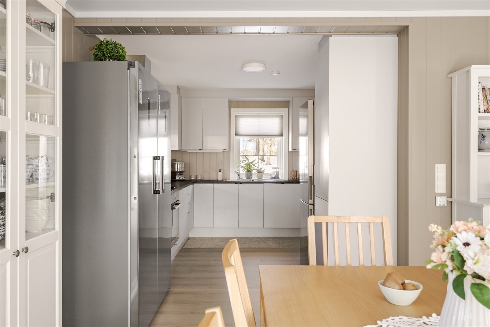 Lys og moderne kjøkkeninnredning fra 2024 med god skap- og benkeplass. Galleribilde