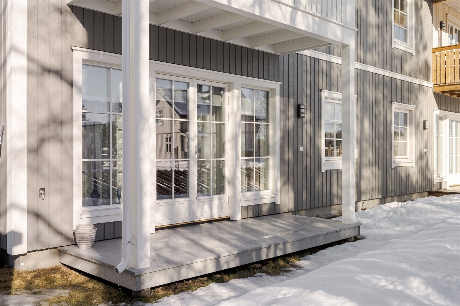Terrassen er overbygget og har terrassebord på gulv. Det er også montert utebelysning, utvendig stikkontakt og utekran. Galleribilde