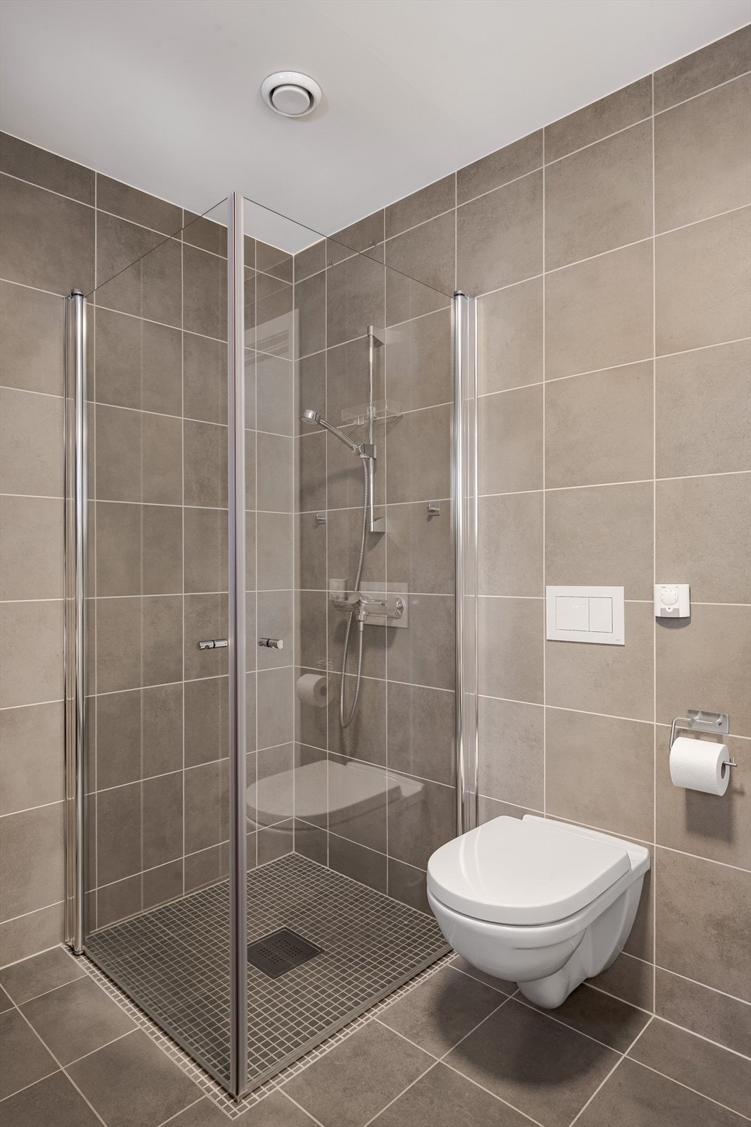 Baderommet er også utstyrt med dusjhjørne med innfellbare glassdører og vegghengt toalett. Galleribilde