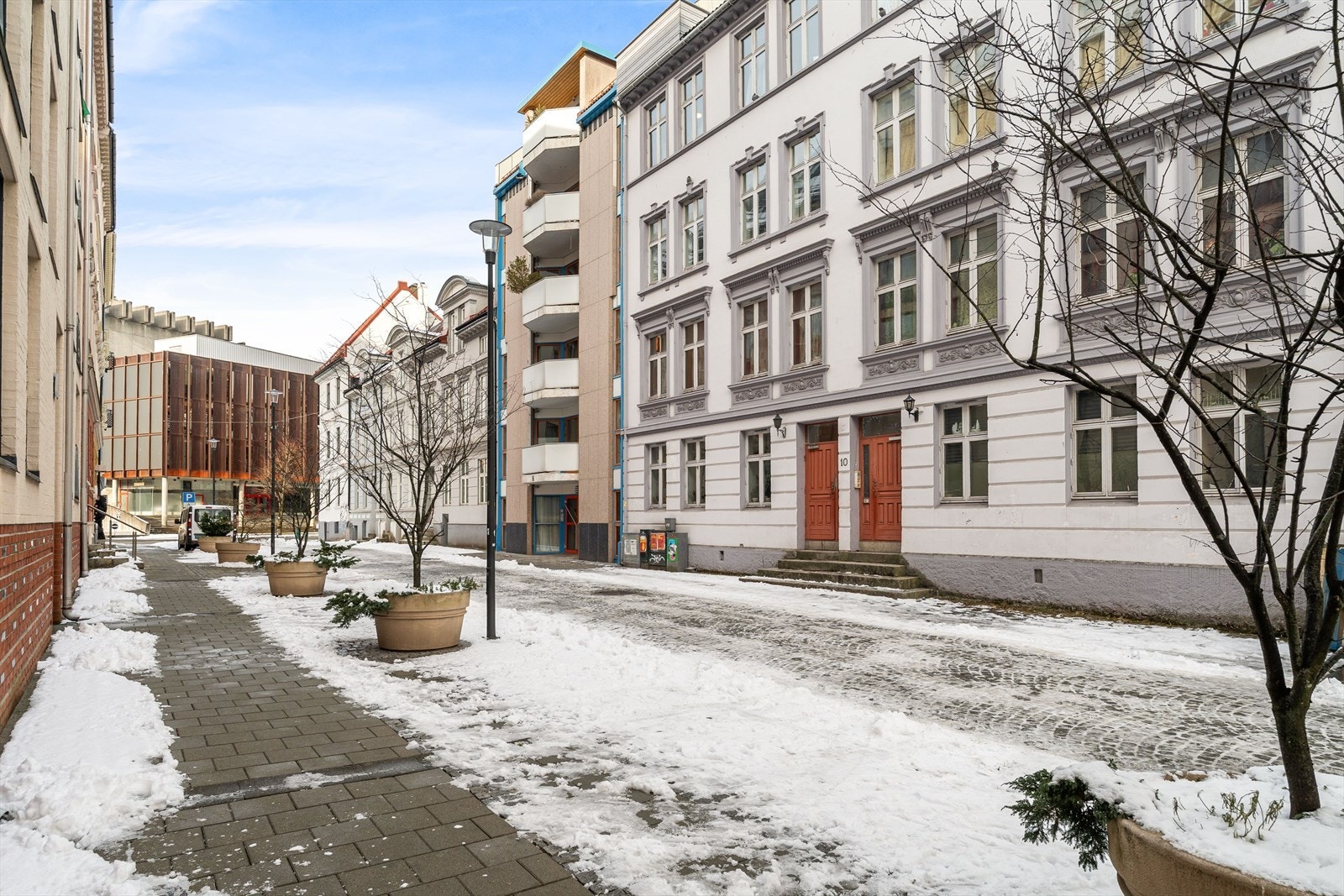 Bygget ligger fint til i bilfri gate | Her bor man sentralt mel likevel skjermet fra det meste. Galleribilde