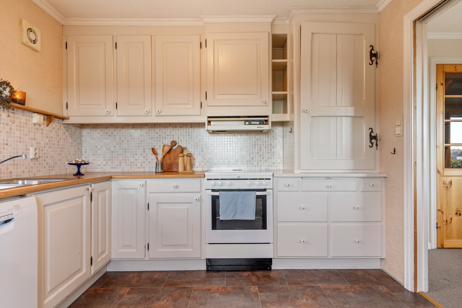 Hvit kjøkkeninnredning med profilerte fronter og laminat benkeplate. Godt med skap og benkeplass. Samt mulighet for spiseplass på kjøkken. Galleribilde