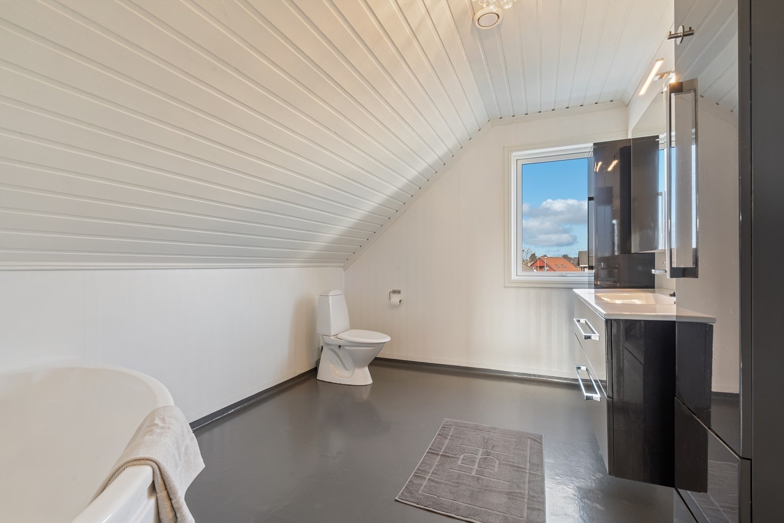 Baderommet på loftet er innredet med wc, vask i seksjon med tilhørende skapinnredning og hjørnebadekar. Galleribilde