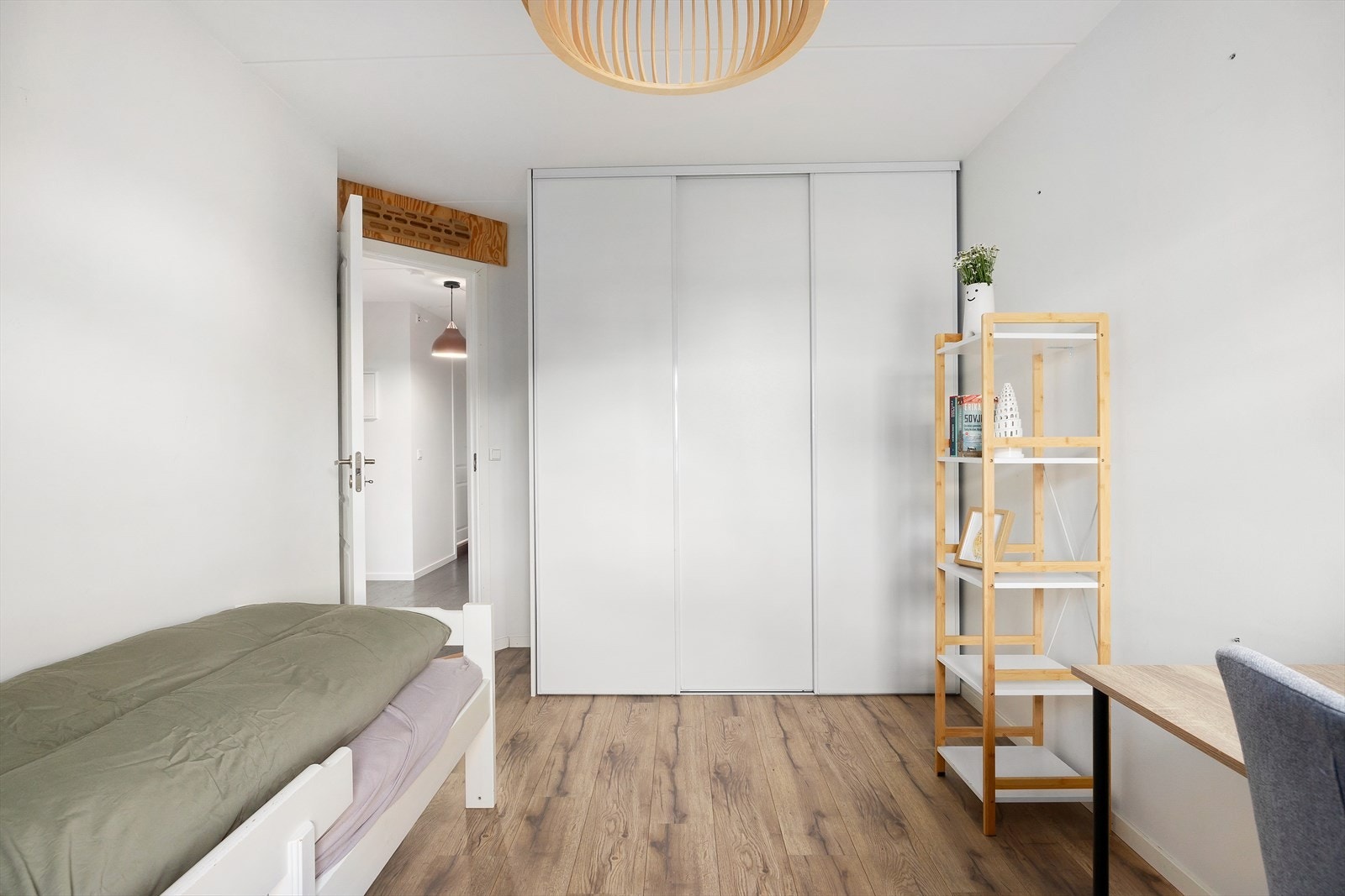 Her står det plassert en romslig skyvedørsgarderobe med hvite glatte skyvedører Galleribilde