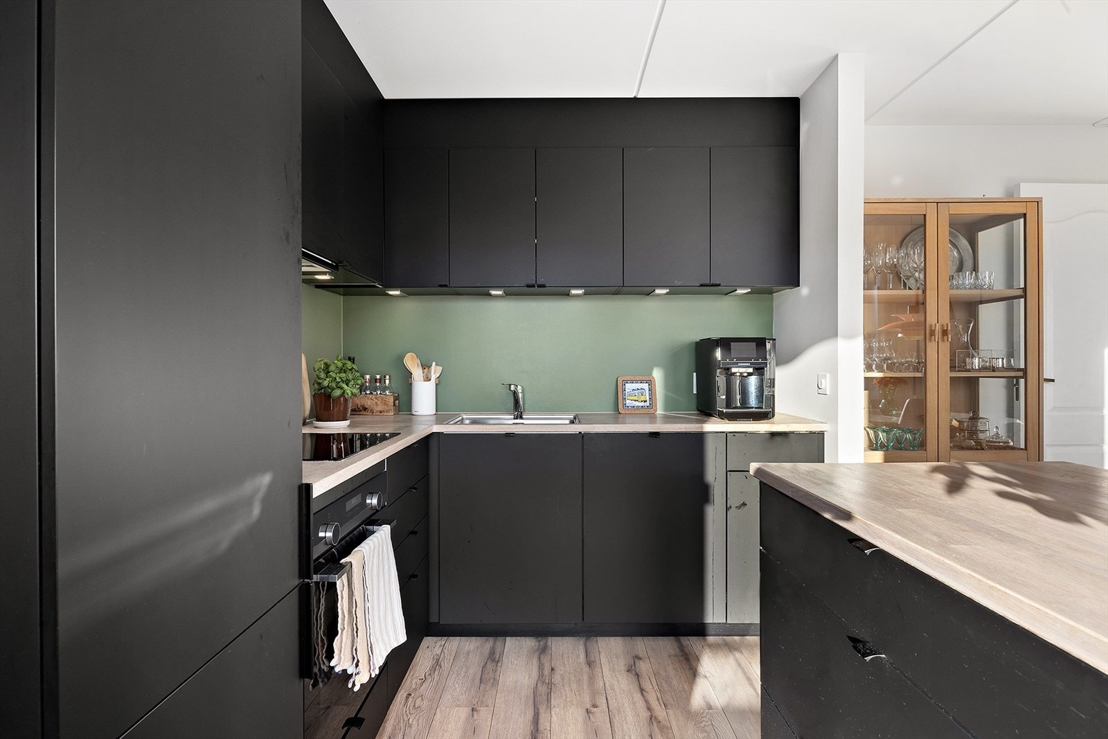 Kjøkkenet innehar integrerte hvitevarer som platetopp, stekeovn, oppvaskmaskin og kjøleskap/fryser Galleribilde