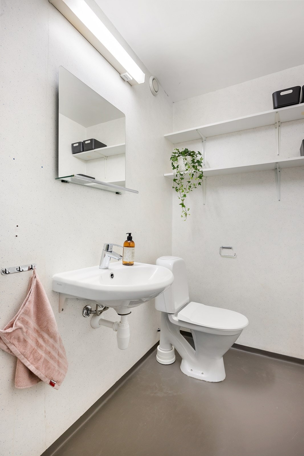 I tillegg har leiligheten et praktisk og separat vaskerom med en innredning bestående av gulvmontert toalett, servant på vegg, speil og opplegg for både vaskemaskin og tørketrommel Galleribilde