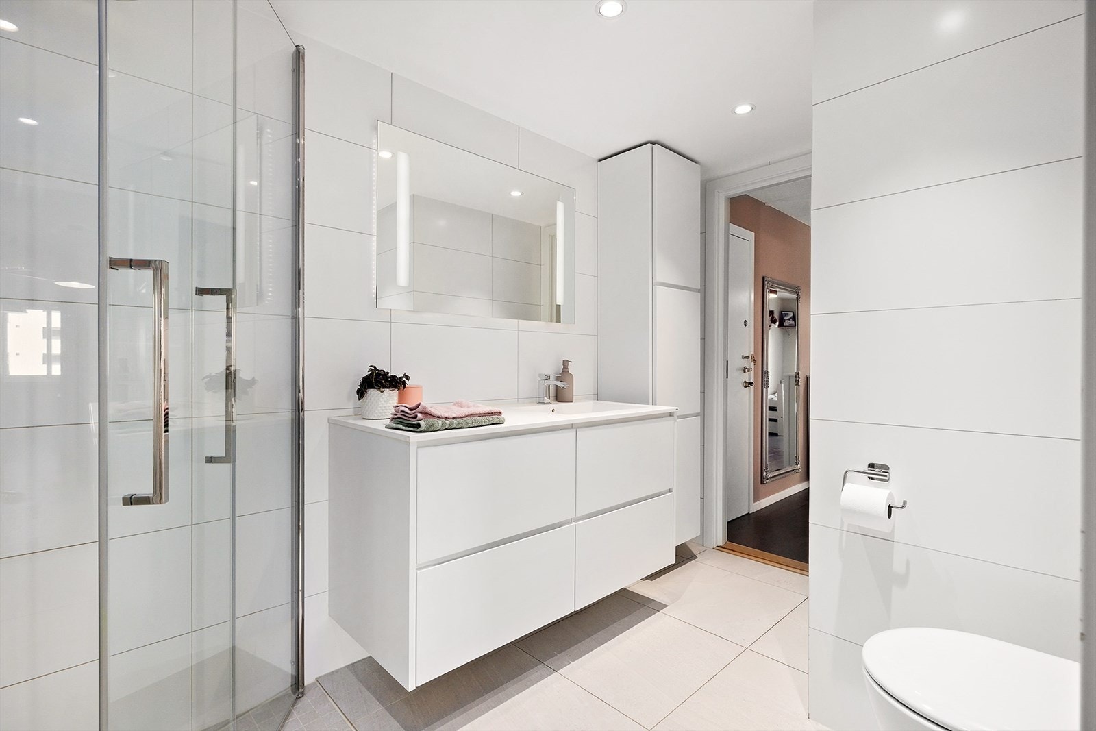 Baderommet har pene flislagte overflater på både gulv og vegger, og lysspotter i himling Galleribilde