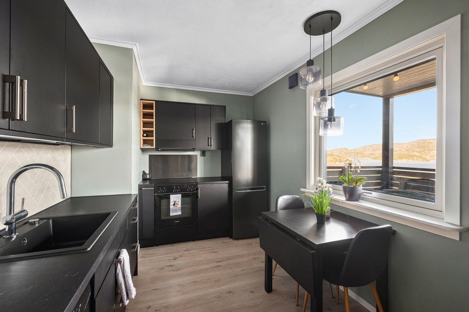 Romslig kjøkken med mørk og moderne kjøkkeninnredning type Epoq fra 2023/24. Hyggelig spiseplass ved kjøkkenvindu, med flott sjøutsikt! Galleribilde