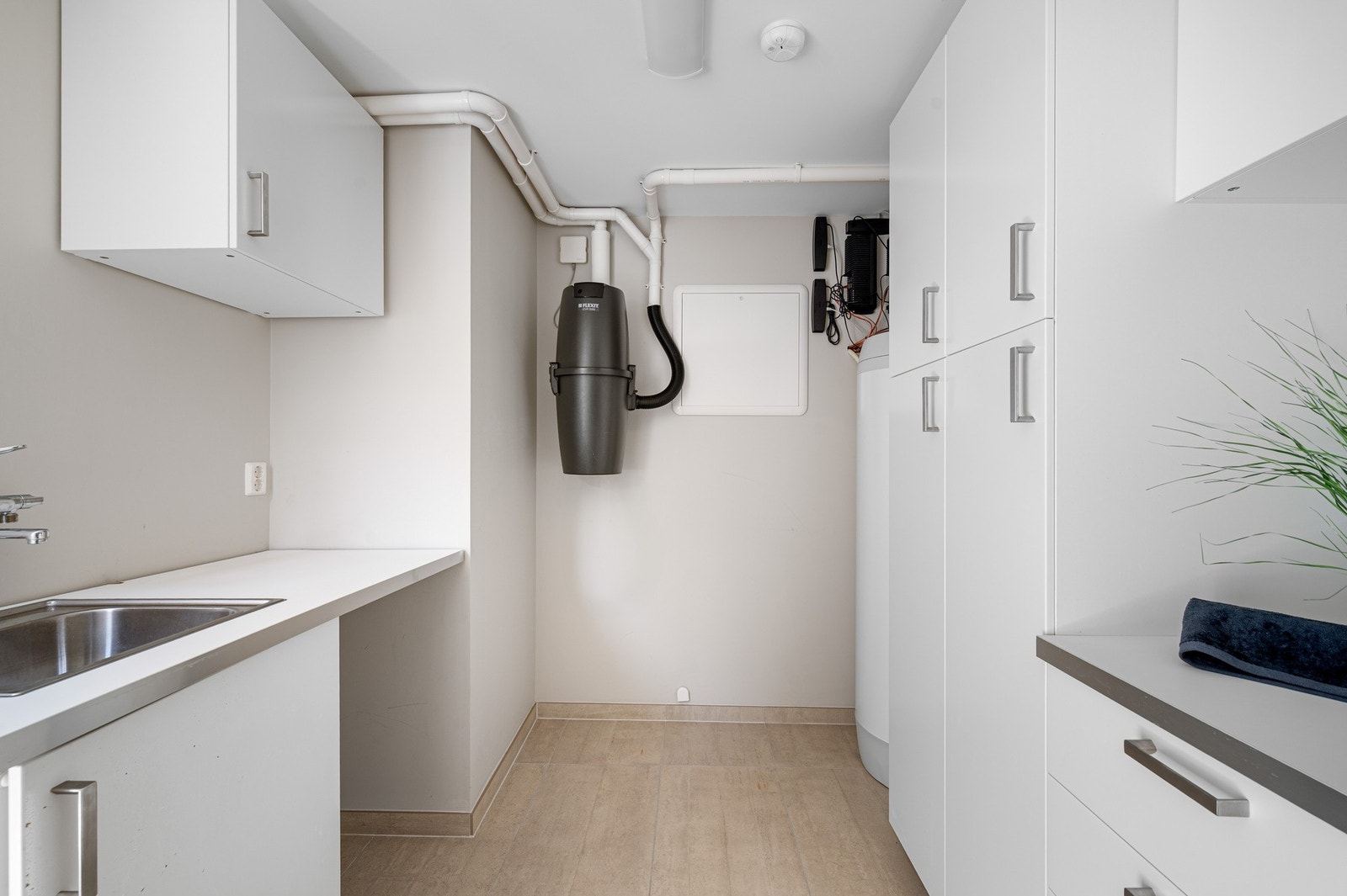 Separat vaskerom med en fin kombinasjon av skap- og benkeplass. Galleribilde