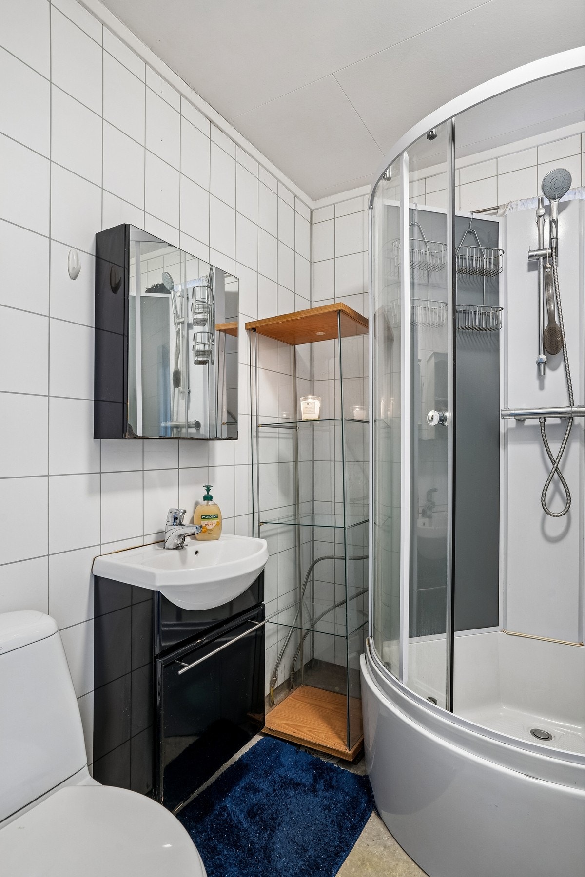 Bad med dusjkabinett, toalett og vask med baderomsinnredning. Galleribilde