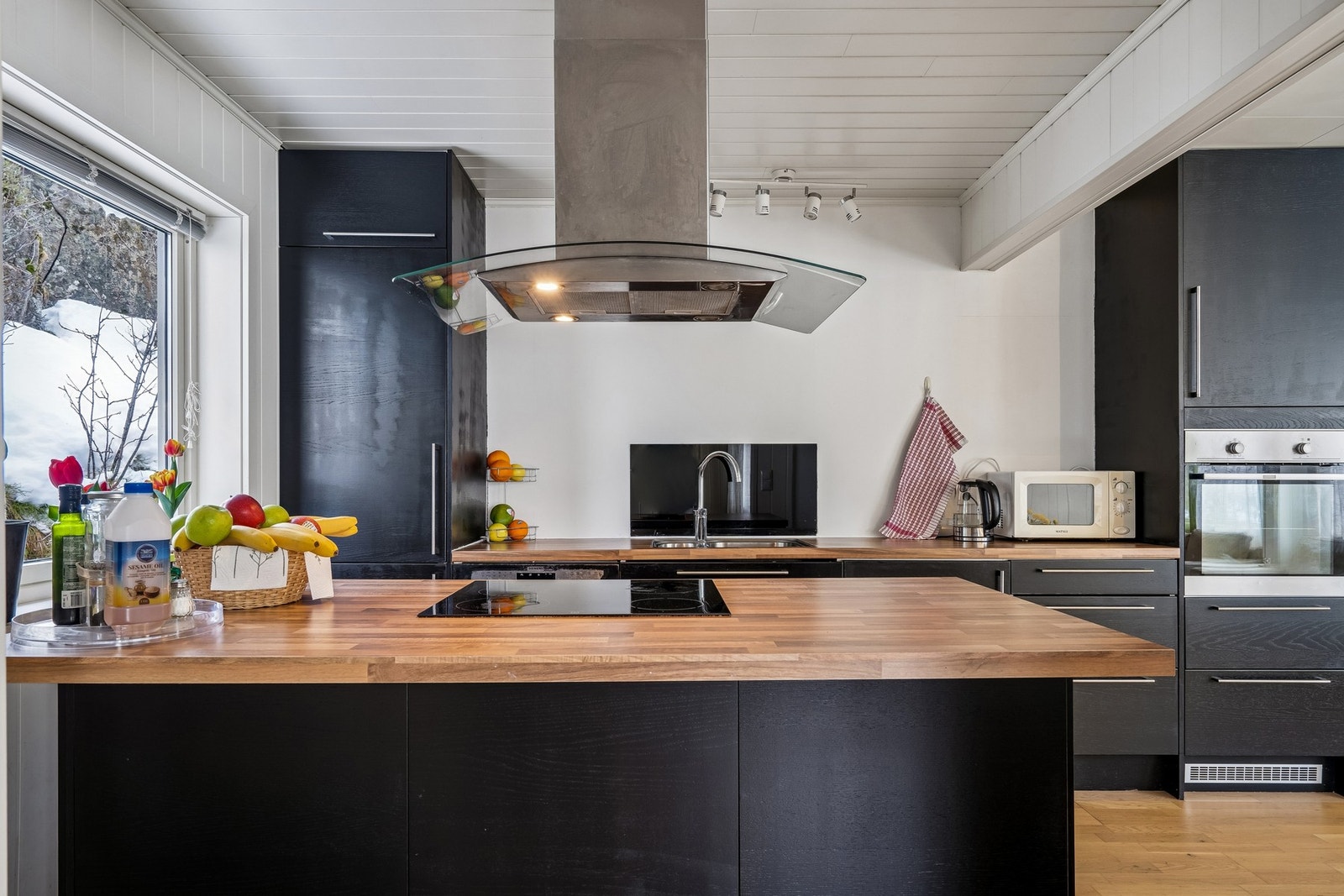 Kjøkkeninnredning med mørke fronter og laminat benkeplate. Galleribilde