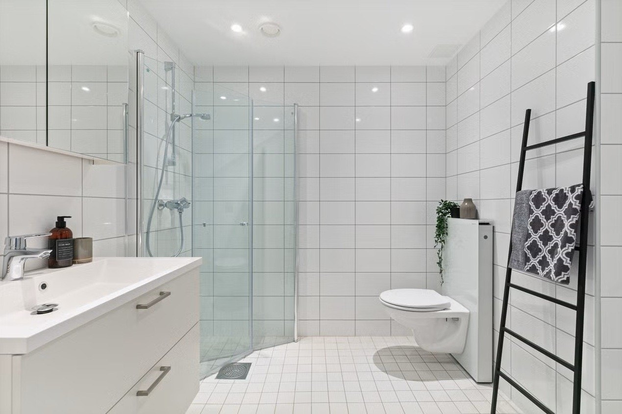 Tidløst flislagt bad med gullvarme og opplegg for vaskemaskin. Galleribilde