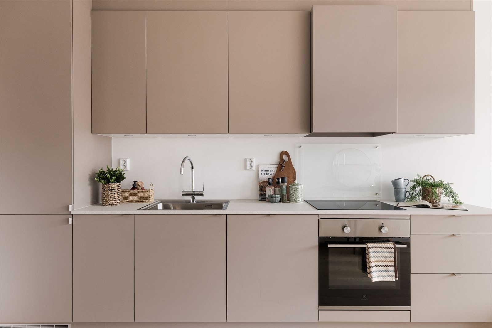 Moderne kjøkkeninnredning fra byggeåret 2024 med glatte fronter i delikat fargetone. Galleribilde