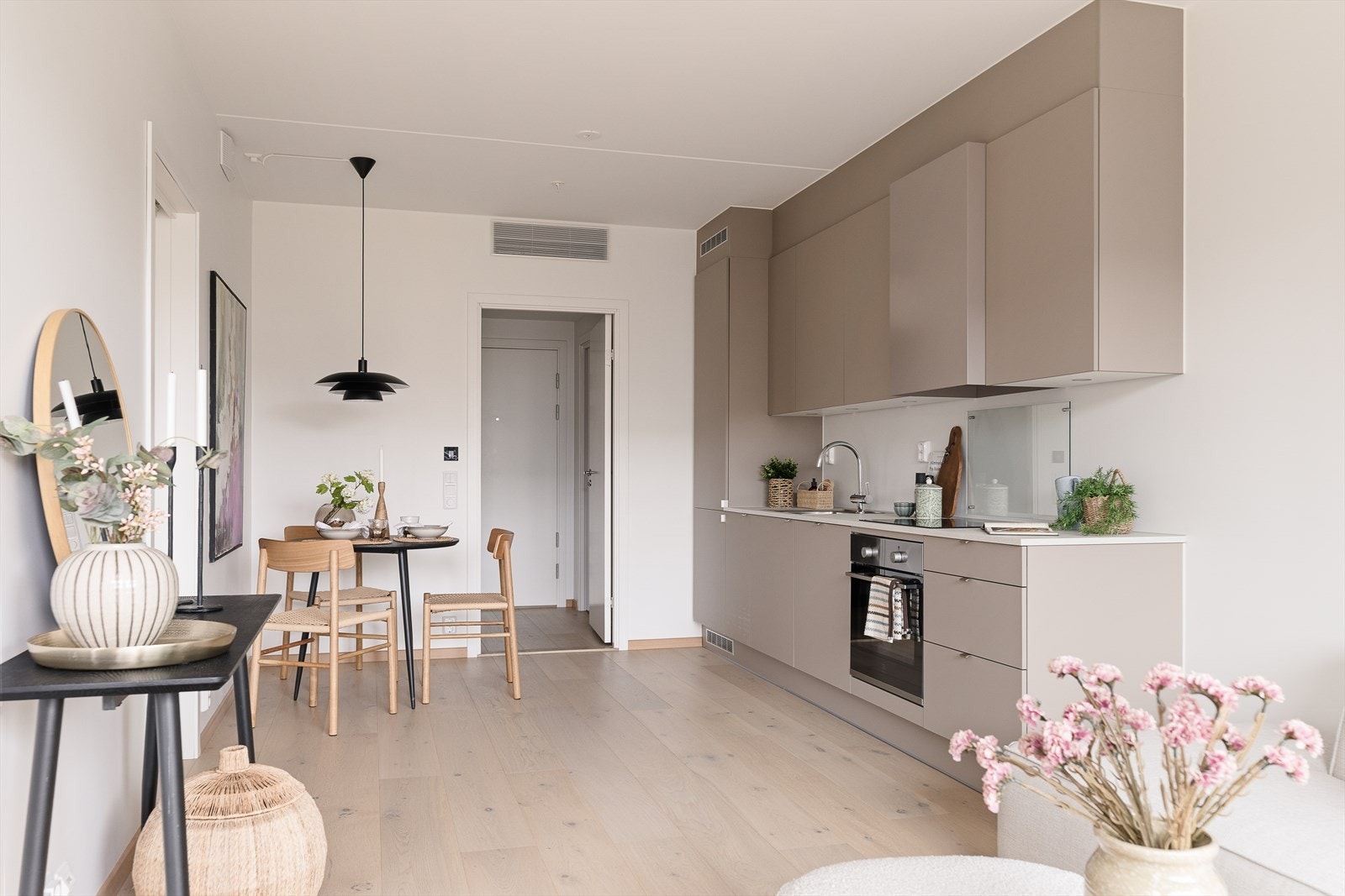 Stuen har åpen løsning mot kjøkkenet og byr på gode møbleringsmuligheter for både sofagruppe og spiseplass. Galleribilde