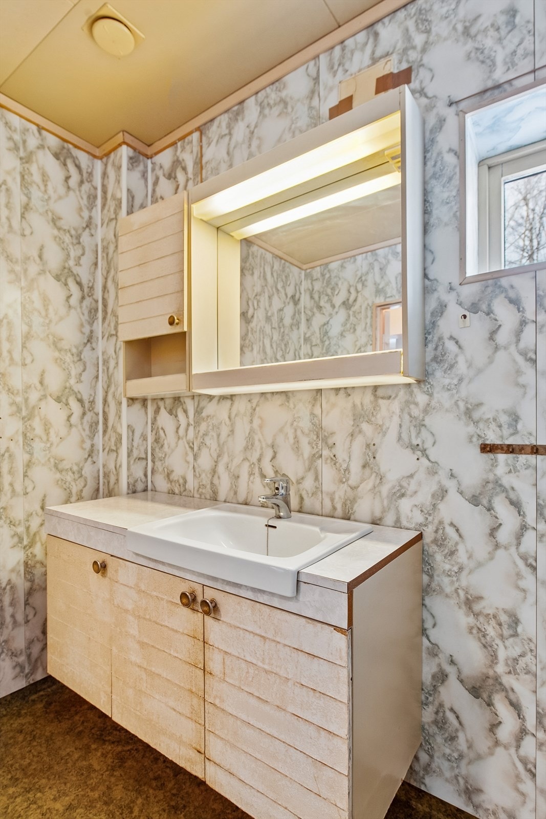 Innredningen består av en laminert benkeplate med nedfelt servant. Innredningen ar stor slitasje. Galleribilde