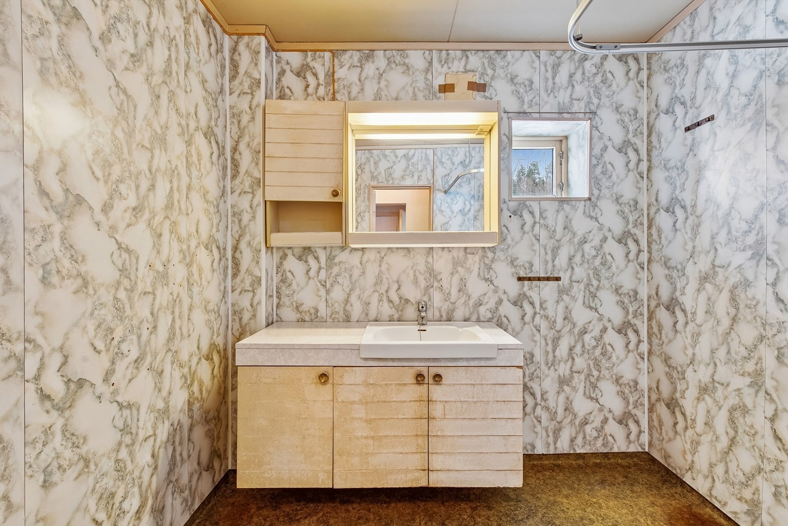 Eldre bad med behov for totalrenovering. Våtromsplater på veggene og belegg på gulvet. Galleribilde