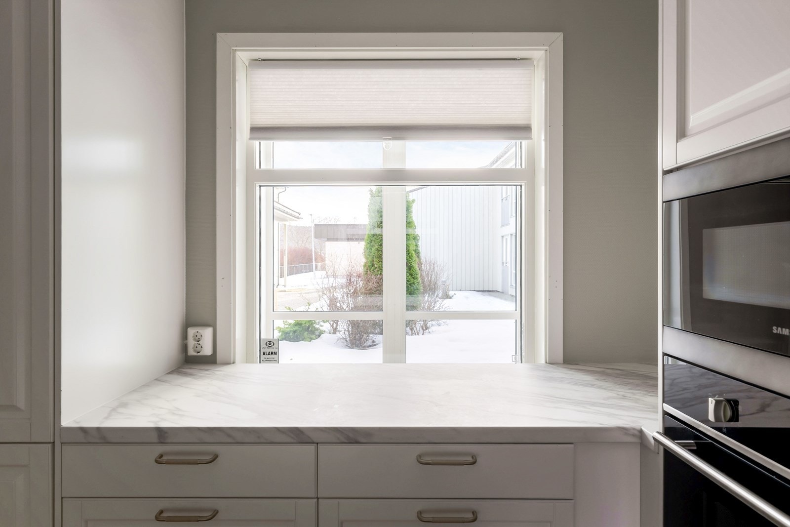 Fra kjøkkenbenken har du fint utsyn fra kjøkkenvinduet mot sameiets tomt. Galleribilde