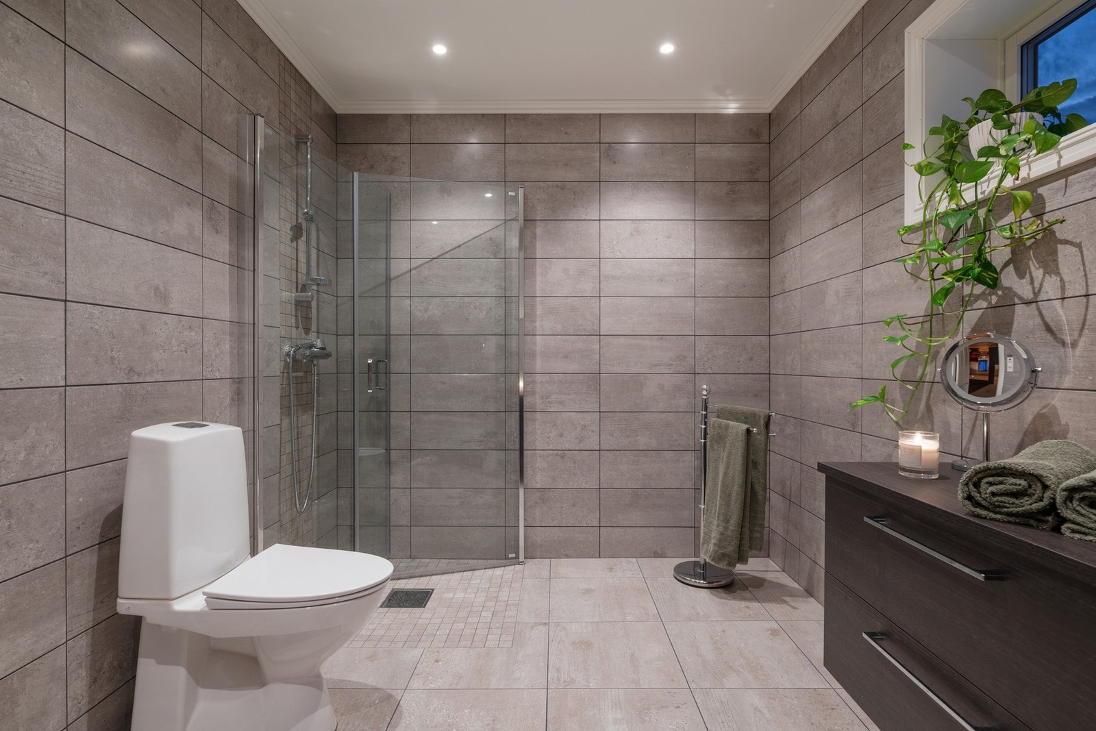 Delikat bad med dusjhjørne, servantinnredning og toalett. Galleribilde