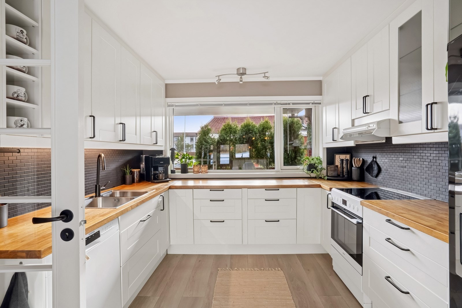 Lyst og stilrent kjøkken fra 2012 har profilerte fronter og rikelig med skap- og benkeplass. Galleribilde