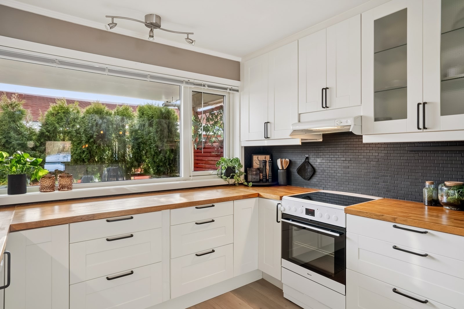 En solid benkeplate i heltre og flislagt vegg over benken gir et varig og stilrent uttrykk. Galleribilde