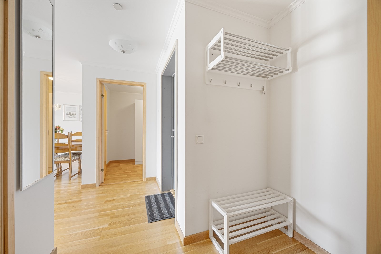 Lys entré i åpen løsning, med fin plass til sko- og yttertøy. I overgang til stuen er det montert praktisk porttelefon med kamerafunksjon. Galleribilde