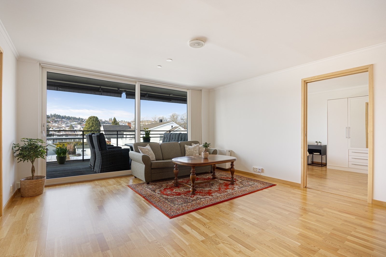 Lys og fin stue av god størrelse, med kjøkken i delvis åpen løsning og skyvedør til en stor, delvis overbygget veranda mot vest. Galleribilde