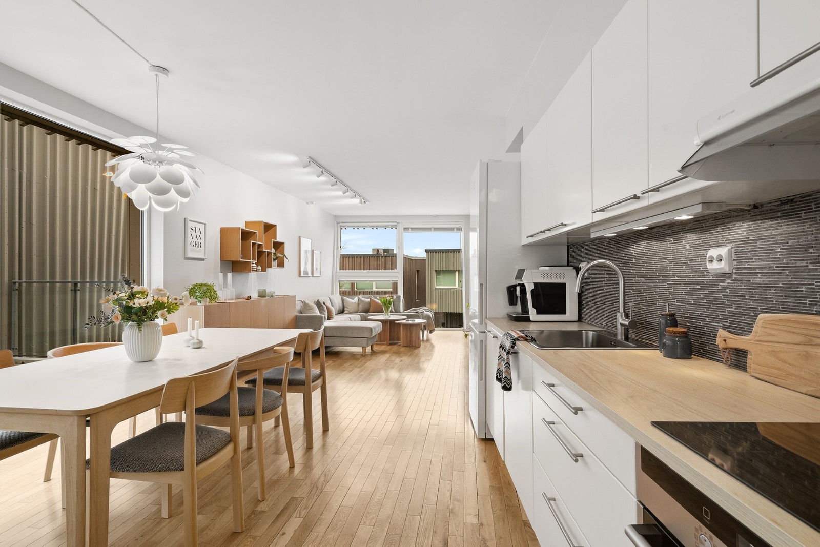 Stor stue og kjøkken i åpen løsning som skaper en luftig og sosial atmosfære. Galleribilde