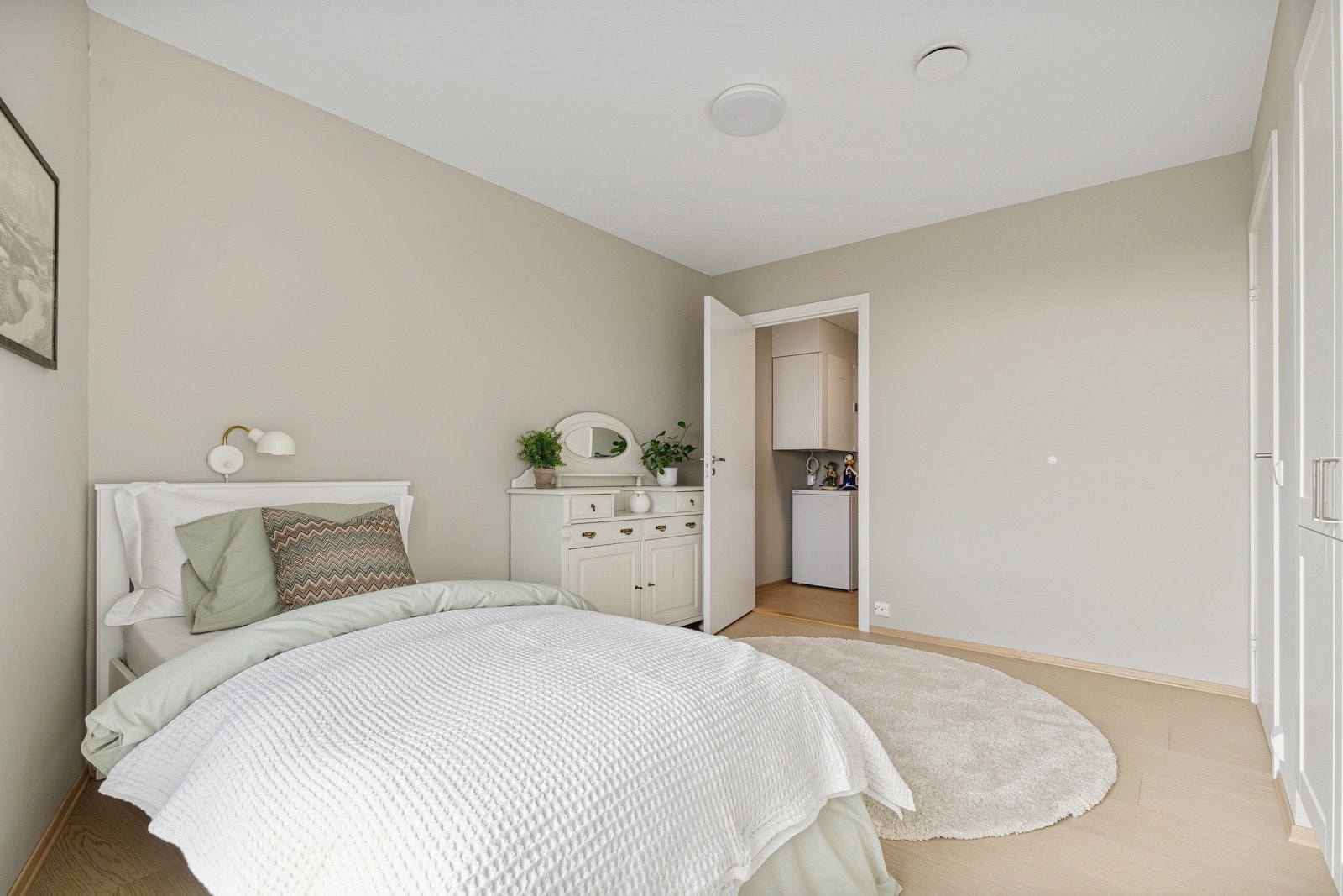 Lyst og romslig soverom med plass til dobbeltseng og tilhørende møblement Galleribilde