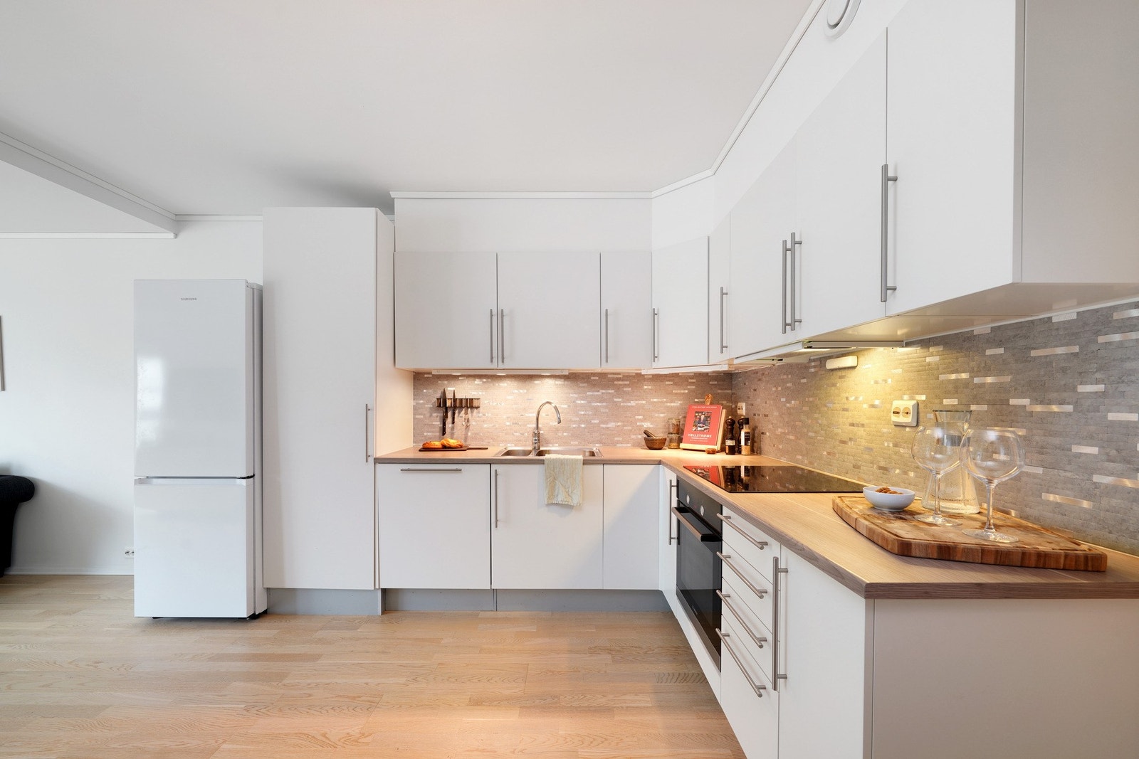 Stilrent kjøkken med god benkeplass hvor stekeovn, platetopp og oppvaskmaskin medfølger handelen Galleribilde