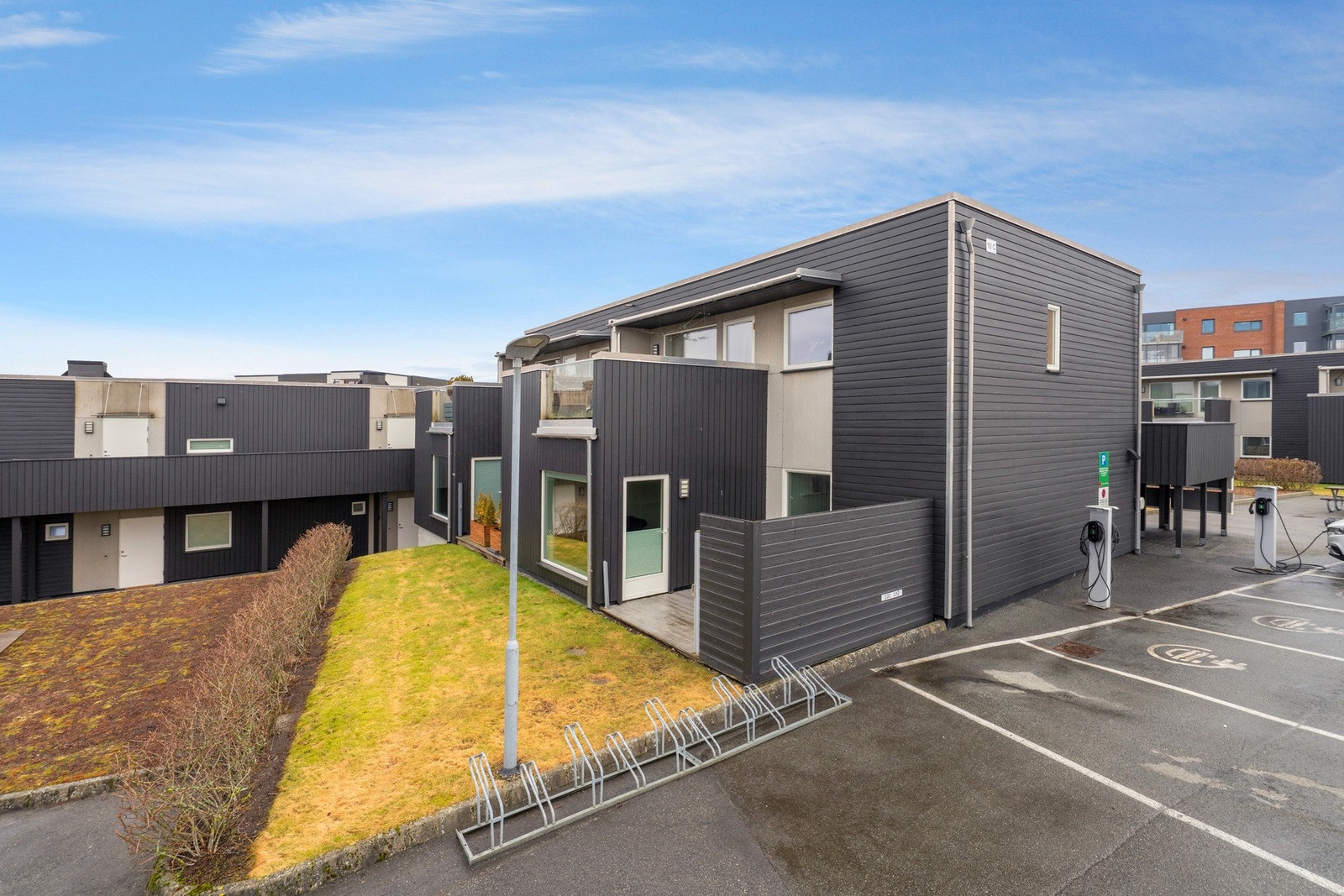 Leiligheten disponerer én biloppstillingsplass på felles tomt, med dedikerte plasser for lading av elbil Galleribilde