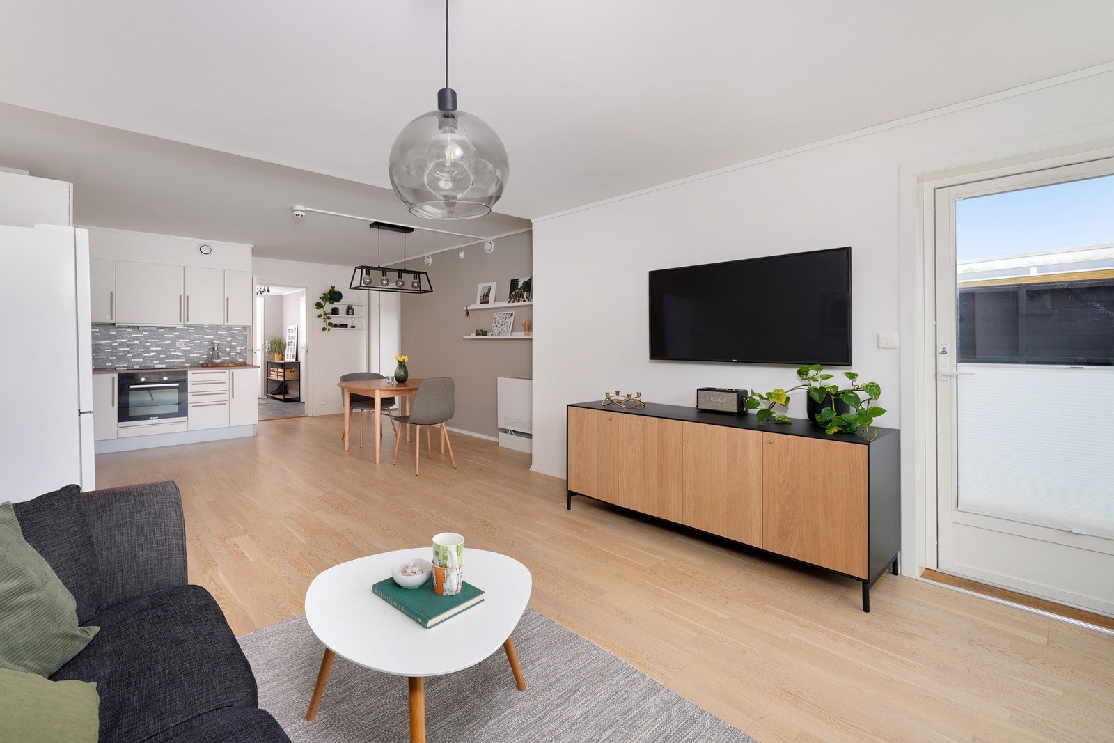 Praktisk åpen løsning mellom stue og kjøkken som gir en romslig og sosial atmosfære Galleribilde