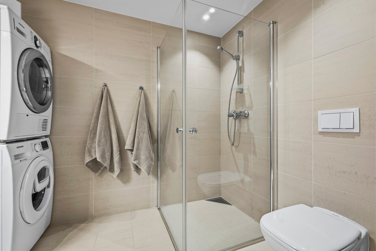 Rommet har veggmontert toalett, opplegg for vaskemaskin, veggspeil med overliggende
belysning, baderomsinnredning med malte fronter og heldekkende servant. Galleribilde