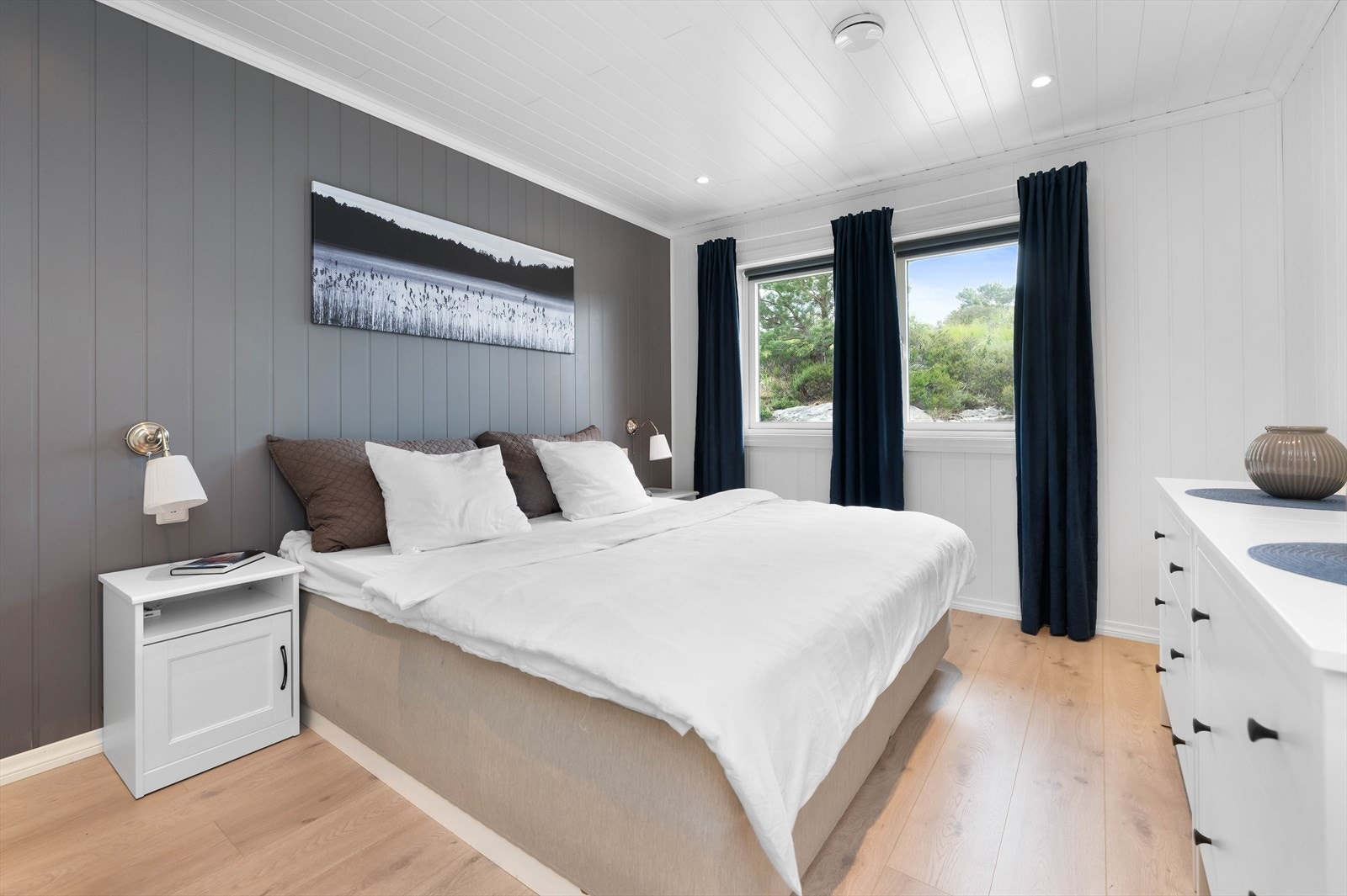 Romslig hovedsoverom med plass til dobbeltseng, nattbord og oppbevaringsmuligheter. Galleribilde