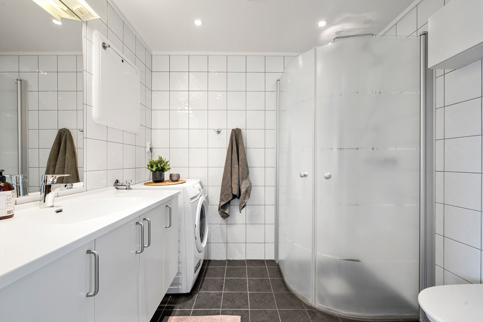Badets 4 kvm er fliselagt og praktisk innredet med plass til dusj, wc, vask og vaskemaskin! Galleribilde