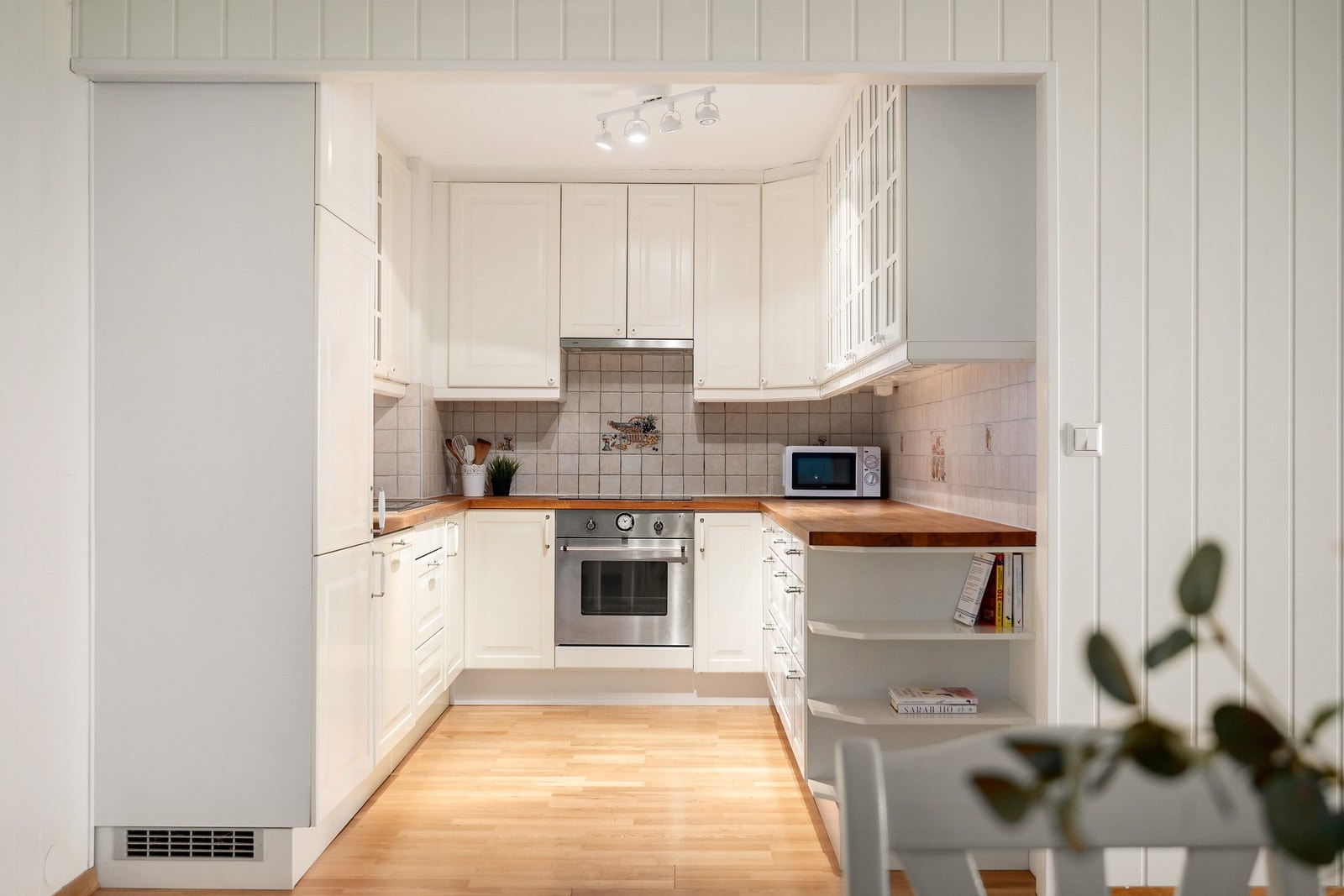 Funksjonelt kjøkken med heltre benkeplate og integrerte hvitevarer. Galleribilde